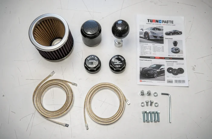 Sélection d'accessoires tuning auto disposés en flat-lay sur un établi d'atelier