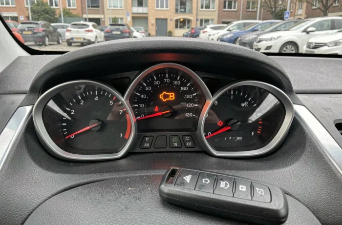 Gros plan sur le voyant clé orange allumé sur le tableau de bord d'une Peugeot 208 avec télécommande de clé visible